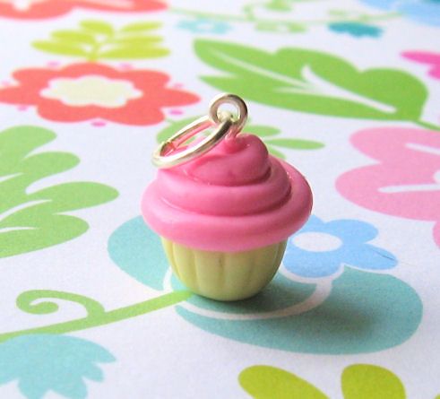 a small pink cupcake with a ring on it