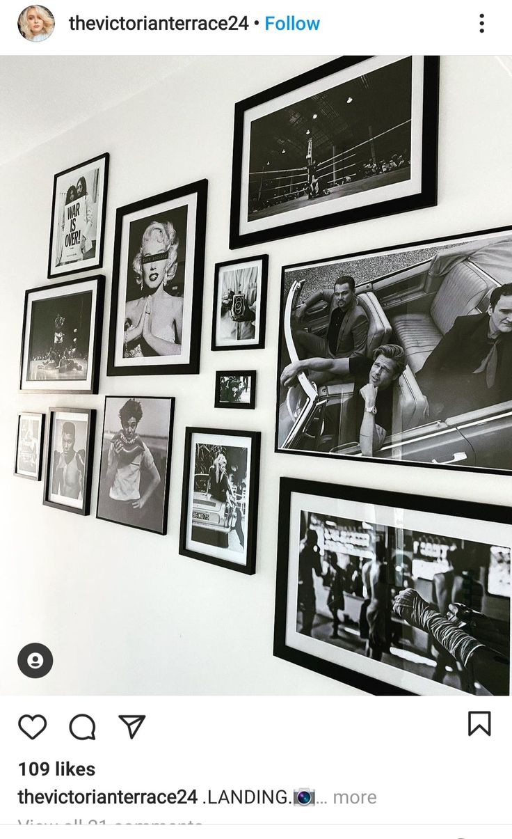 black and white photograph on the wall with many framed photos hanging above it, along with an instagram tweet