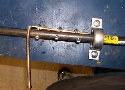 the back end of a metal object with two screws and a yellow stick sticking out of it