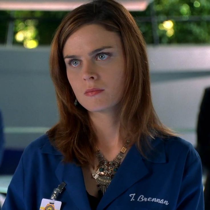 a woman in scrubs is looking at the camera with serious expression on her face