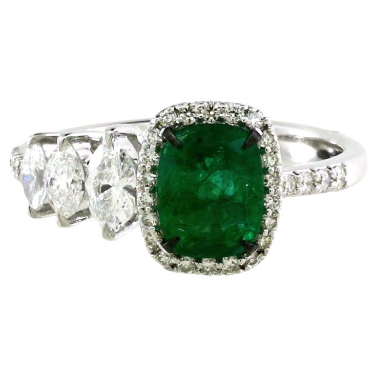 This ring is a celebration of sophistication and timeless beauty. At its heart, a mesmerizing emerald cushion-cut gemstone, weighing 0.80 carats, commands attention with its rich, verdant allure. On one side, three exquisite marquise-cut diamonds, totaling 0.38 carats, add a touch of graceful asymmetry, enhancing the central emerald's charm. A brilliant display of 30 white round diamonds, with a total weight of 0.21 carats, adorn the ring's setting, lending it a luminous and luxurious quality. C Elegant Green Gia Certified Gemstones, Luxury Cushion Cut Gemstones With Prong Setting, Gia Certified Elegant Emerald Gemstones, Elegant Gia Certified Emerald Gemstones, Elegant Cushion Cut Gemstones, Elegant Cushion Cut Gemstone With Center Stone, Elegant Cushion Cut Gemstones With Prong Setting, Classic Cushion Cut Brilliant Gemstones, Luxury Cushion Cut Gemstones For Wedding