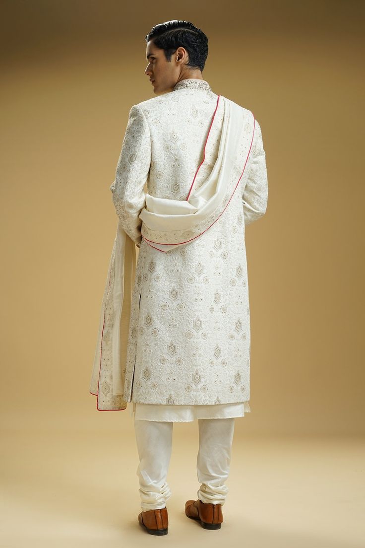 Off-white silk dupion sherwani with floral jaali embroidery. Comes with a cotton silk kurta, churidar, and a stole.
Component: 4
Pattern: Embroidered
Type Of Work: Floral jaali
Neckline: Mandarin collar
Sleeve Type: Full
Fabric: Silk dupion, Kurta : Cotton silk
Color: Off White
Other Details: 
Embellished buttons on front placket
Embroidered borders on stole
Occasion: Groom, Wedding - Aza Fashions Stole For Men, Embellished Buttons, Kurta Cotton, Silk Kurta, Fabric Silk, Churidar, White Silk, Mandarin Collar, Cotton Silk