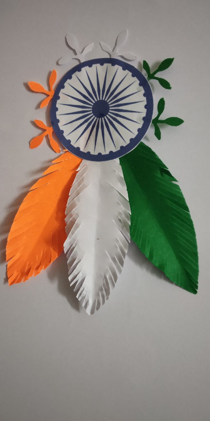 three different colored paper leaves on a white table top with the colors of india and green