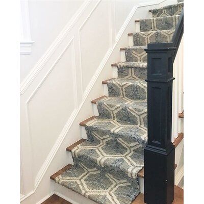 a staircase with carpeted steps leading up to the second floor