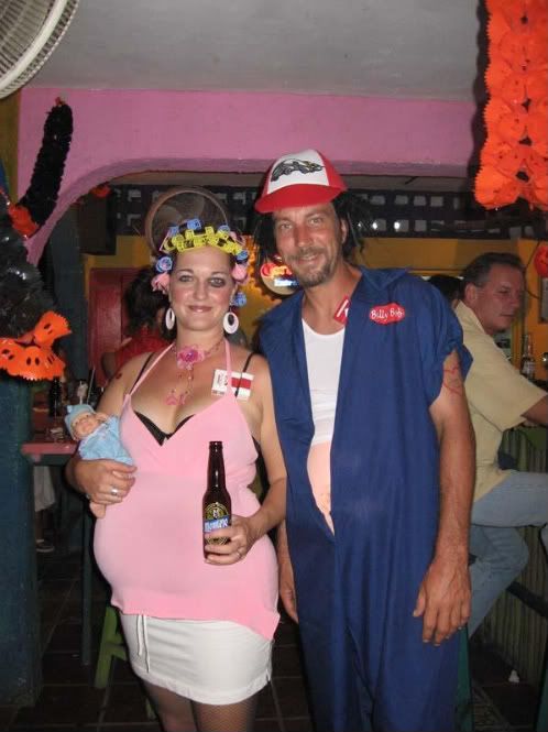 a man and woman dressed in costumes standing next to each other with beer bottles on their heads