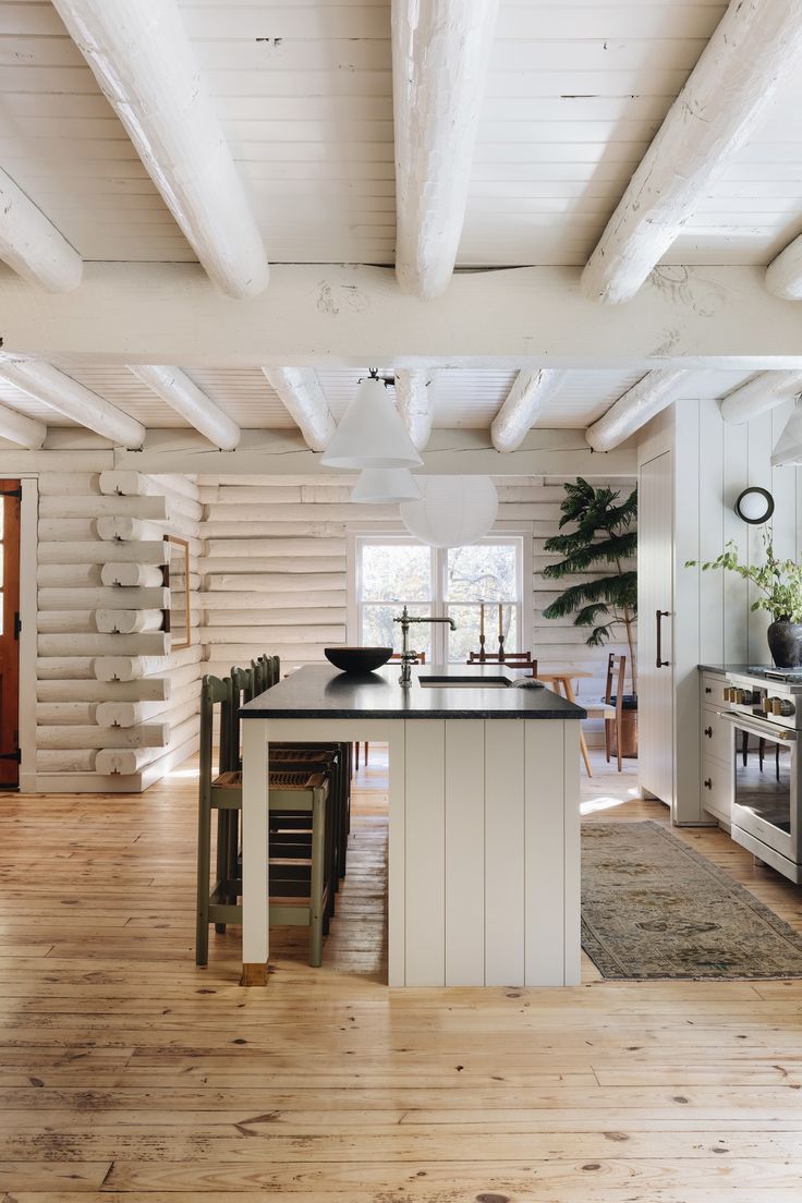 a kitchen with white walls and wooden floors