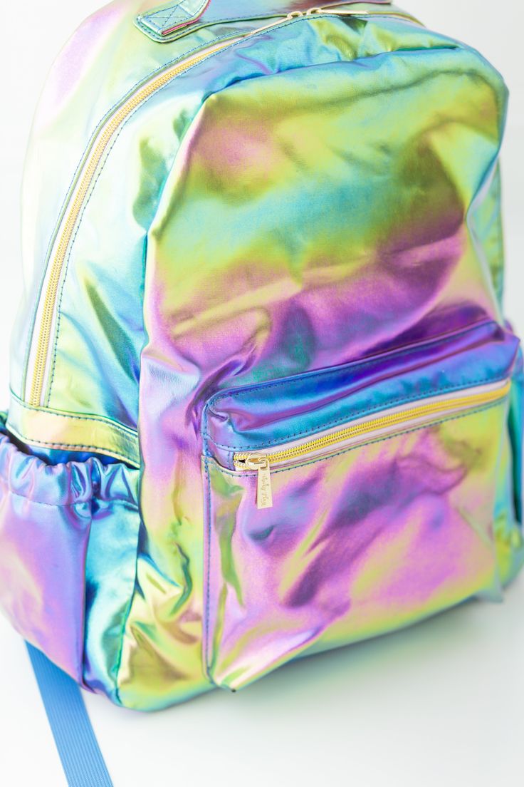 Make a statement with our Bree Backpack - Metallic Rainbow! Perfect for those who want to stand out in the crowd, this fun backpack is the ultimate accessory. Add some sparkle to your back to school look and make it one that everyone will remember! Standard Size: 16" H x 12.5" W x 6.5" D Standard size backpack easily holds folders or 3-ring binders for school Handle on top for easy carrying One zippered exterior front pocket Two exterior side pockets sized to fit water bottles Adjustable padded Iridescent Backpack For Everyday Use, Iridescent Standard Backpack For Everyday Use, Binders For School, Fun Backpack, Patriotic Accessories, Girls Halloween Outfits, Patriotic Dresses, School Look, Metallic Rainbow