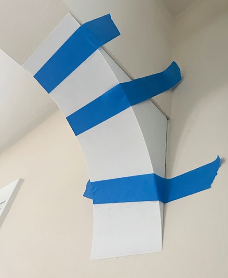 a piece of paper taped to the ceiling with blue and white strips on it,