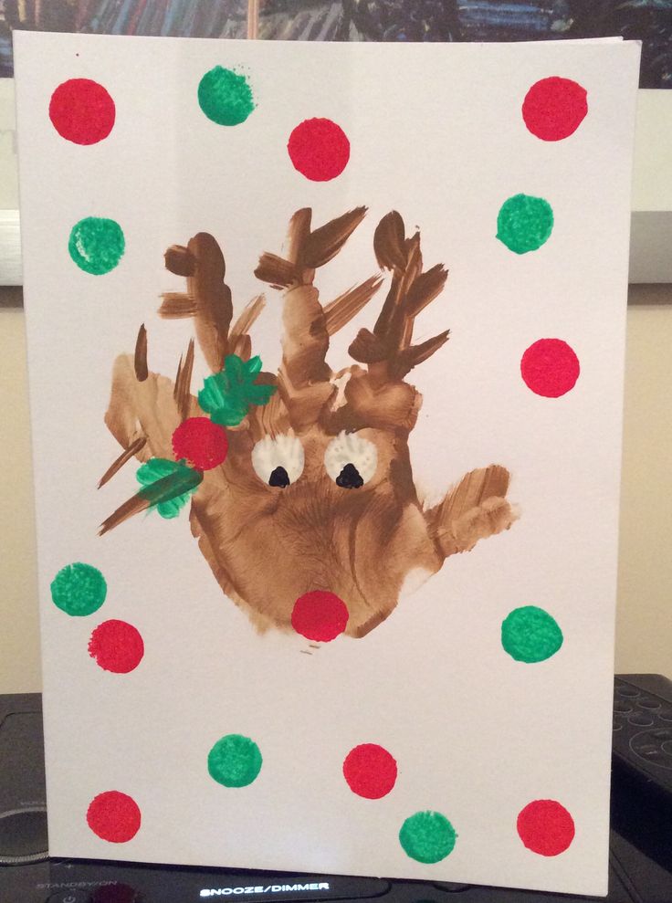 a paper bag with a handprint of a reindeer on it and polka dots around it