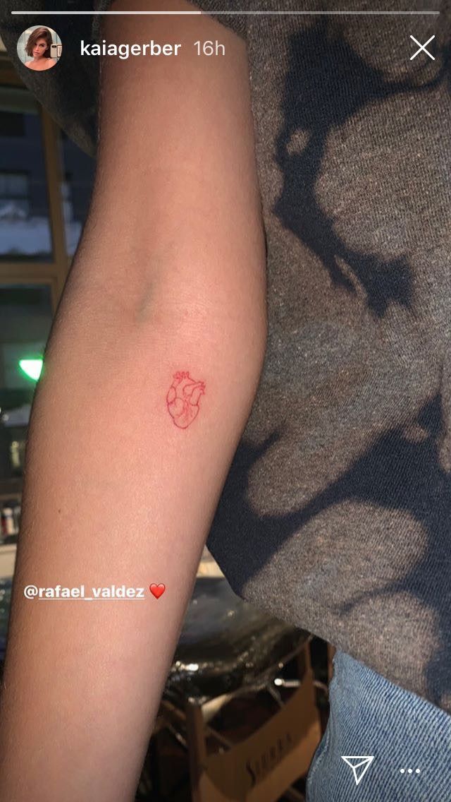 a person with a red tattoo on their arm and the word love written in it