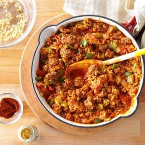 a bowl filled with food sitting on top of a wooden table next to bowls of sauce