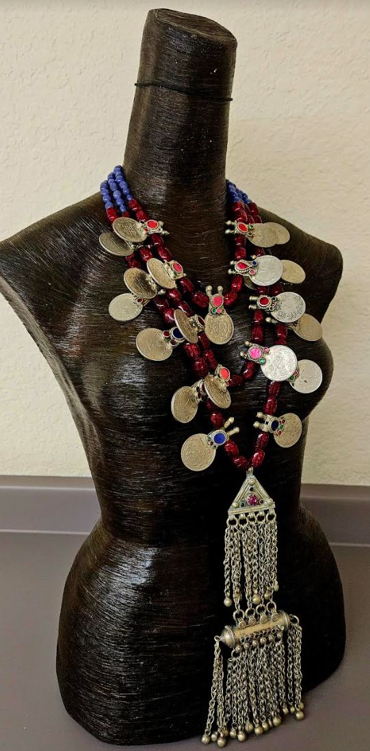 This gorgeous triple strand beaded tribal - ethnic chest piece is of moderate weight. Three strands of ruby red Czech barrel glass and purple agate beads separate the inlaid glass Architectural coins and complete the back. A very rare, vintage, double Waziri or Kuchi scroll pendant is the focal point of the piece with completely intact chain dangles and inlaid glass. The pendant measures 9.5" x 3.5". The back is finished with silver tone hardware, a lobster claw clasp and a 3" extender chain with a coin accent. This adjusts from 20-23". OOAK Wearable Art from the Atelier of Kat Kouture! Red Bohemian Necklaces For Traditional Ceremonies, Bohemian Beaded Necklaces For Traditional Ceremonies, Bohemian Red Necklaces For Traditional Ceremonies, Traditional Multi-strand Silver Beaded Necklace, Traditional Red Beads For Festival, Traditional Multi-strand Beads For Festivals, Bohemian Beads For Traditional Ceremonies And Festivals, Red Bohemian Necklace For Ceremonial Occasions, Jewellery Shop Design