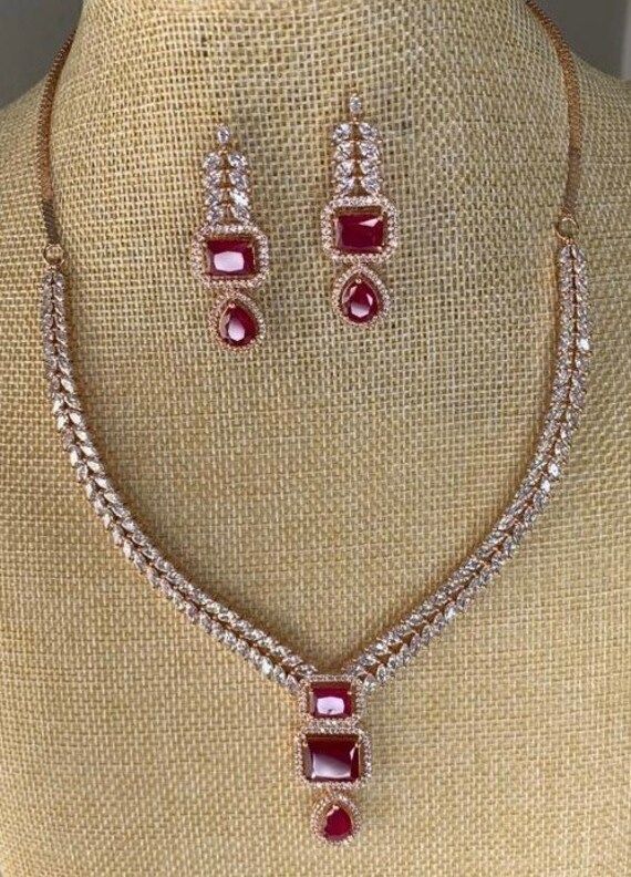 American Diamond with red stone necklace and earrings set. Elegant Red Necklace For Festive Occasions, Elegant Red Necklace With Stones, Formal Red Stone Necklaces, Red Stone Jewelry For Celebration, Red Stone Necklace For Formal Occasions, Red Stone Necklaces For Formal Occasions, Elegant Red Stone Jewelry, Elegant Red Necklace With Stone Setting, Red Ruby Stone Setting Necklace