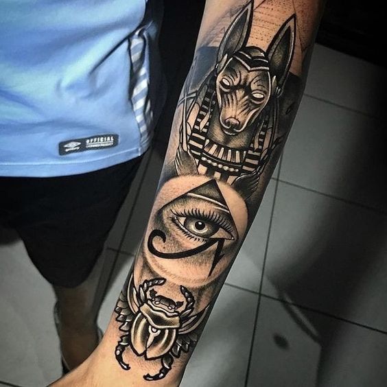 an arm tattoo with egyptian symbols on it and the eye of horush in the center