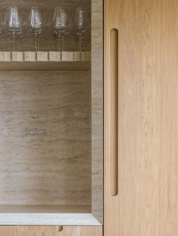 the wine glasses are lined up on the shelf in the cabinet next to the door