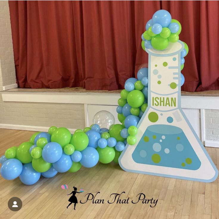 a science themed party with balloons and streamers in the shape of a beakle