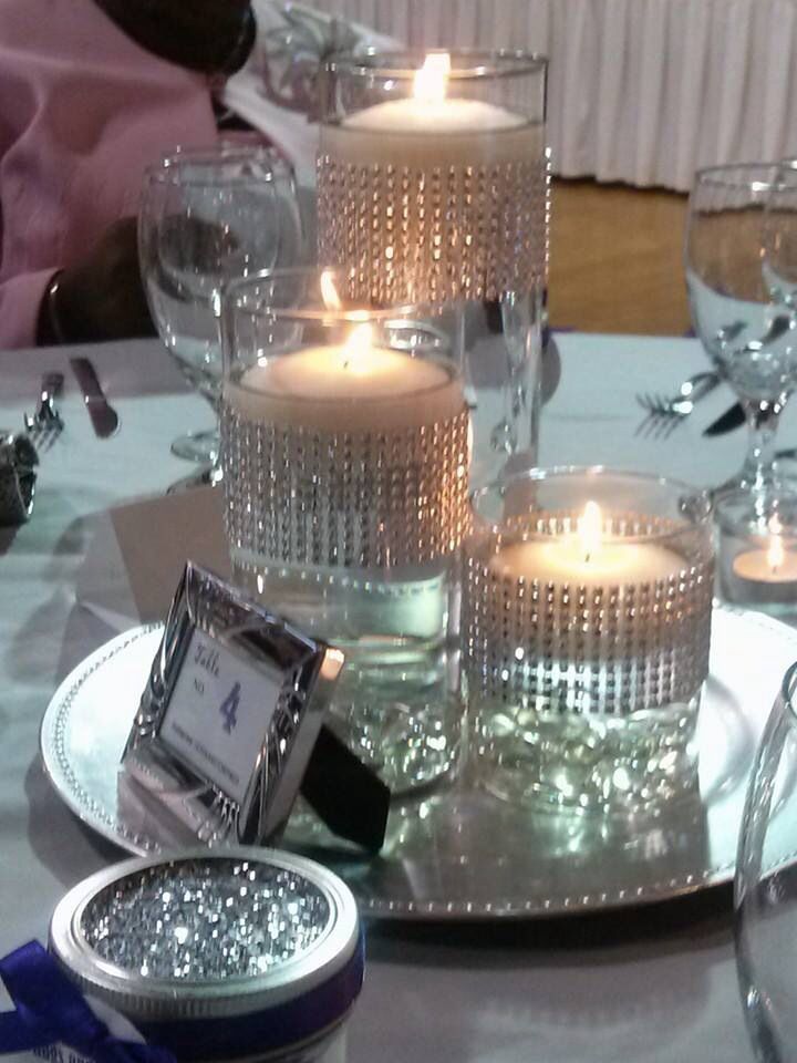 a table topped with lots of candles next to plates and silverware on top of a table