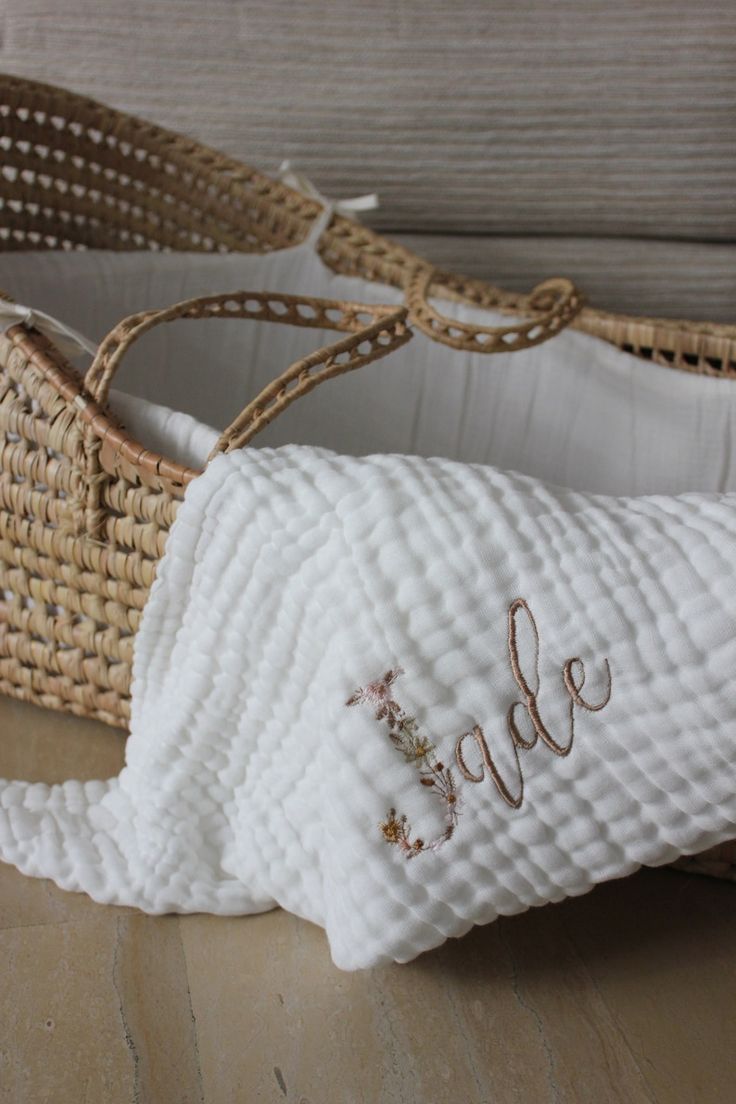 a pair of white shoes with embroidered words on them, sitting next to a wicker basket