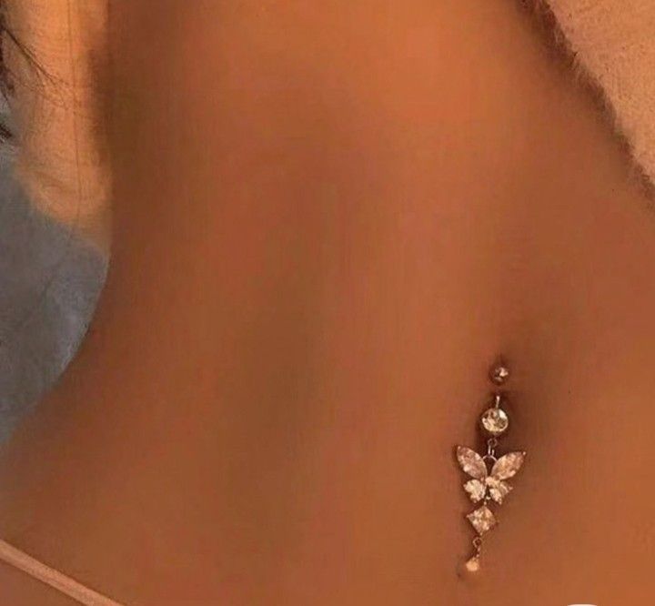 the back of a woman's stomach with a butterfly brooch pin on it