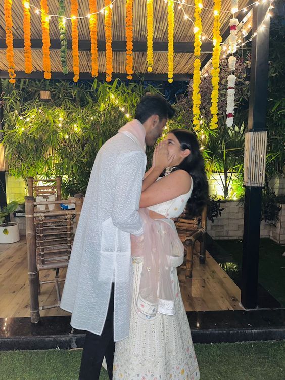 a man and woman standing next to each other in front of a wooden gazebo