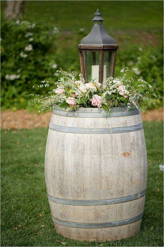 a wooden barrel with flowers in it and a lantern on top is displayed for the camera