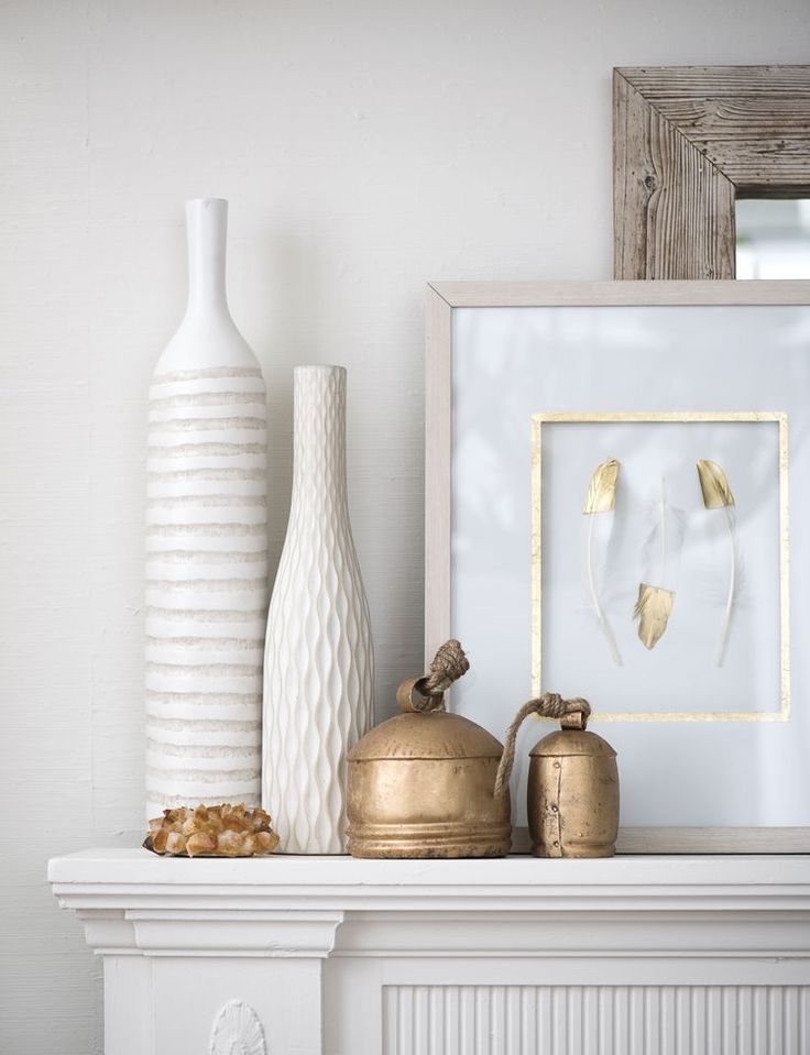 a white mantle with vases and other items on it, along with a framed photograph