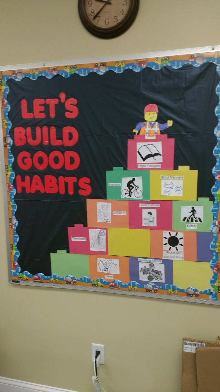 a bulletin board that says let's build good habitts on the wall next to a clock