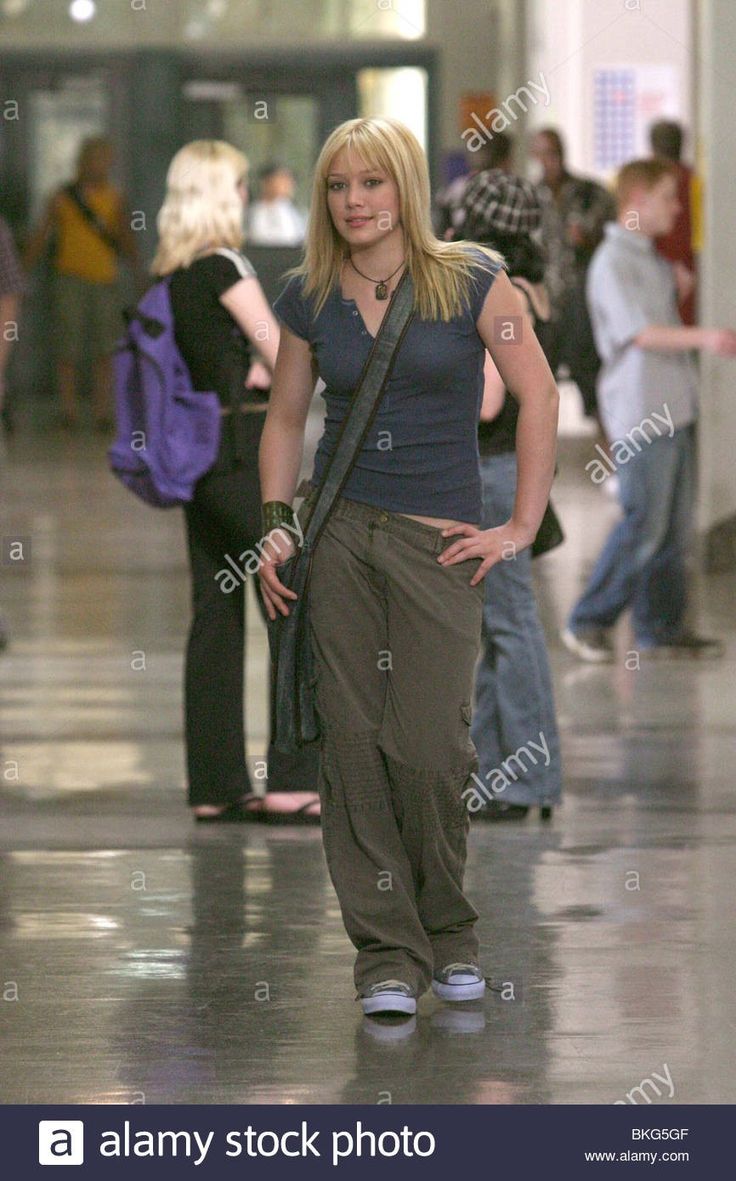 a woman is walking through an airport with her hand on her hip