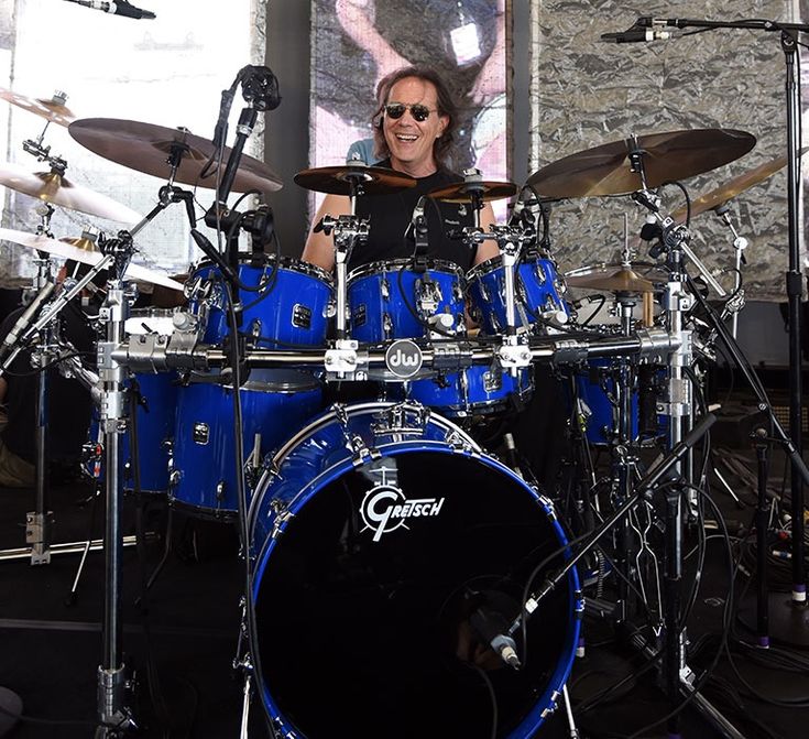 a man sitting behind a blue drum set