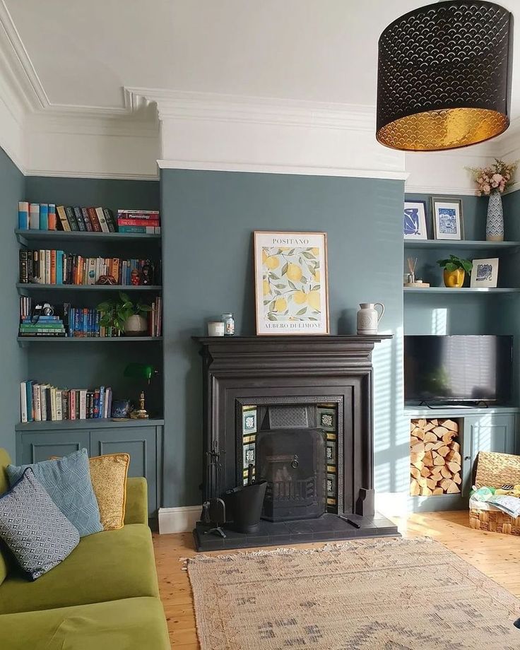 a living room filled with furniture and a fire place next to a book shelf full of books