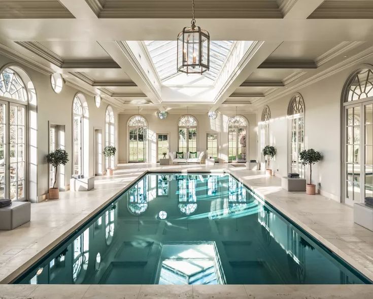 a large indoor swimming pool in the middle of a room with high ceilings and arched windows