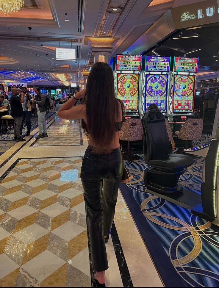 a woman standing in front of slot machines at a casino