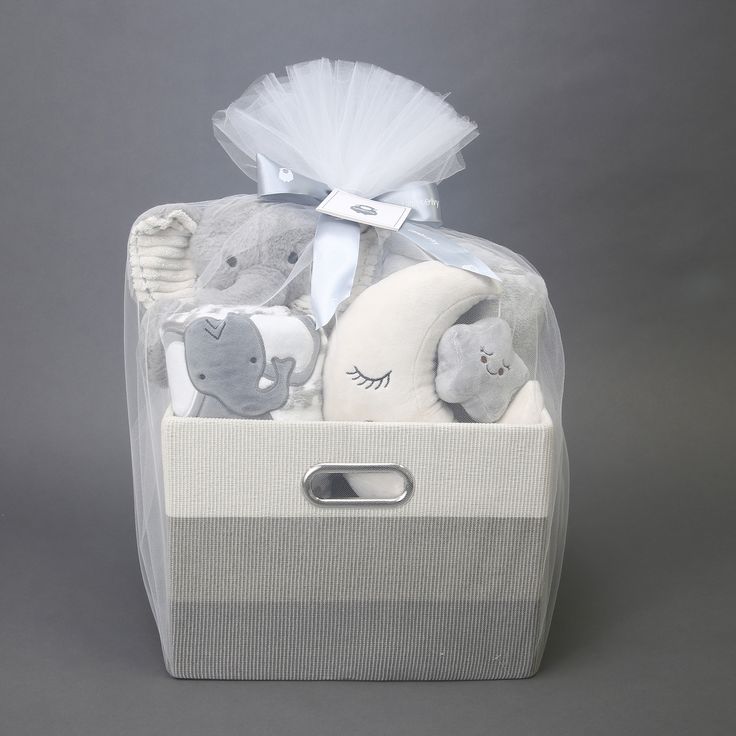 a white basket with stuffed animals in it on a gray background and tied to the side