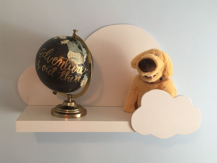 a teddy bear sitting on top of a shelf next to an earth globe and cloud