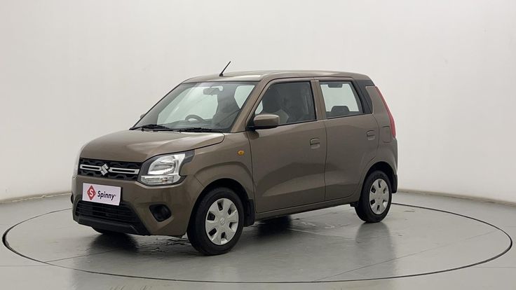 a small brown car is parked on a round surface