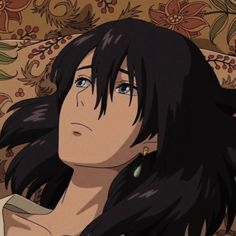 a woman with long black hair sitting in front of a floral wallpaper and looking off to the side