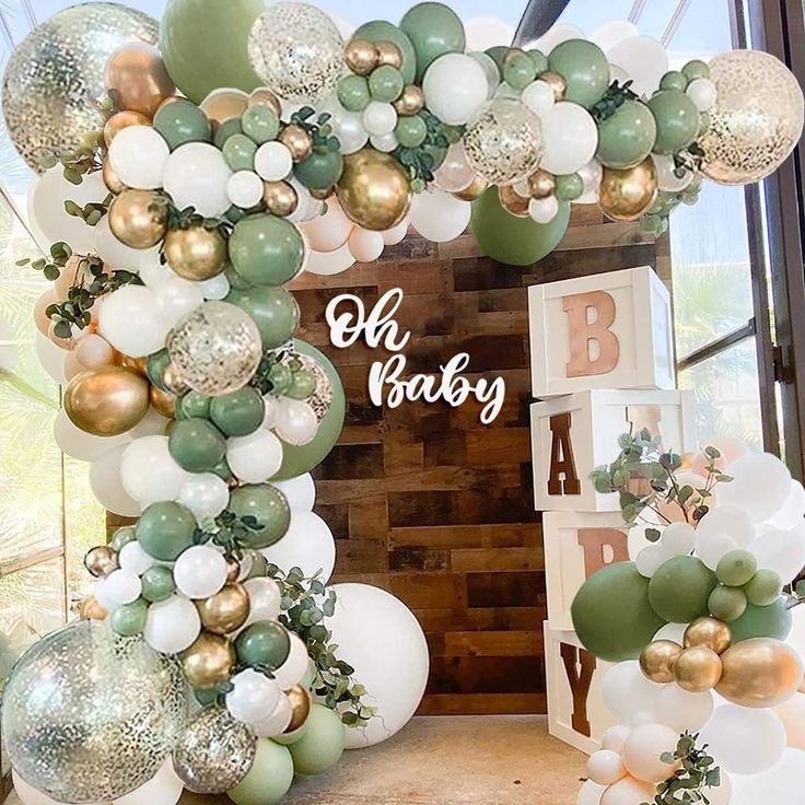 a baby shower is decorated with balloons and greenery