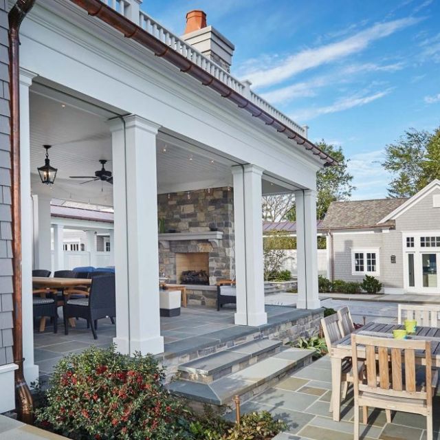 an outdoor dining area with patio furniture and stone steps leading up to the back door