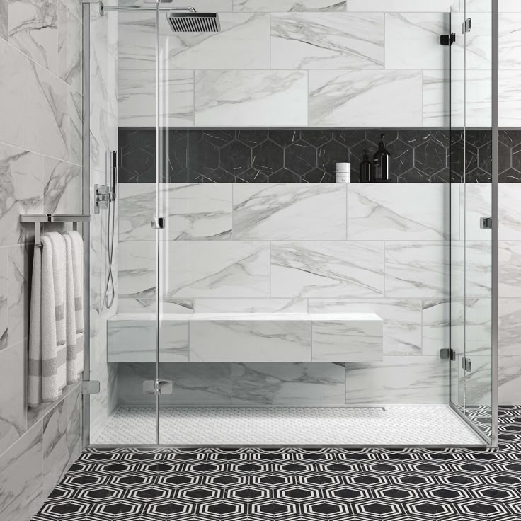 a bathroom with black and white tile flooring and walls, along with a walk in shower