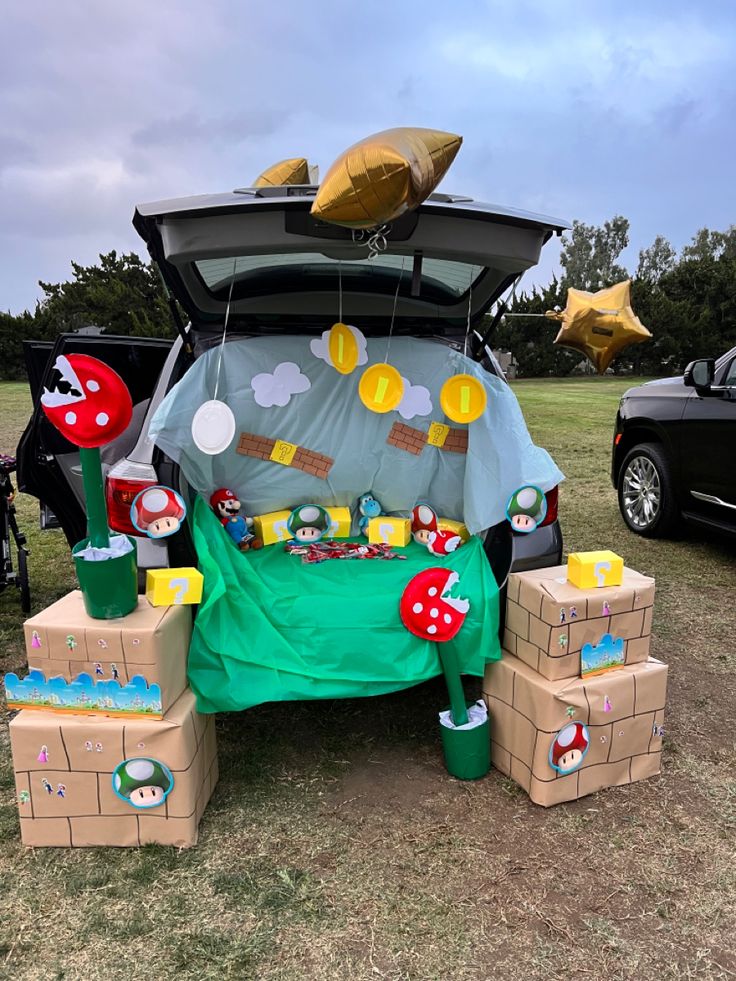 the trunk of a car is decorated with cardboard boxes and mario's mushroom decorations