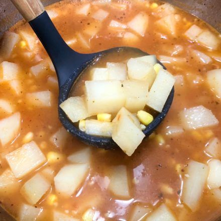 a wooden spoon in a pot filled with stew