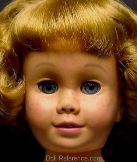 an old doll with blonde hair and blue eyes