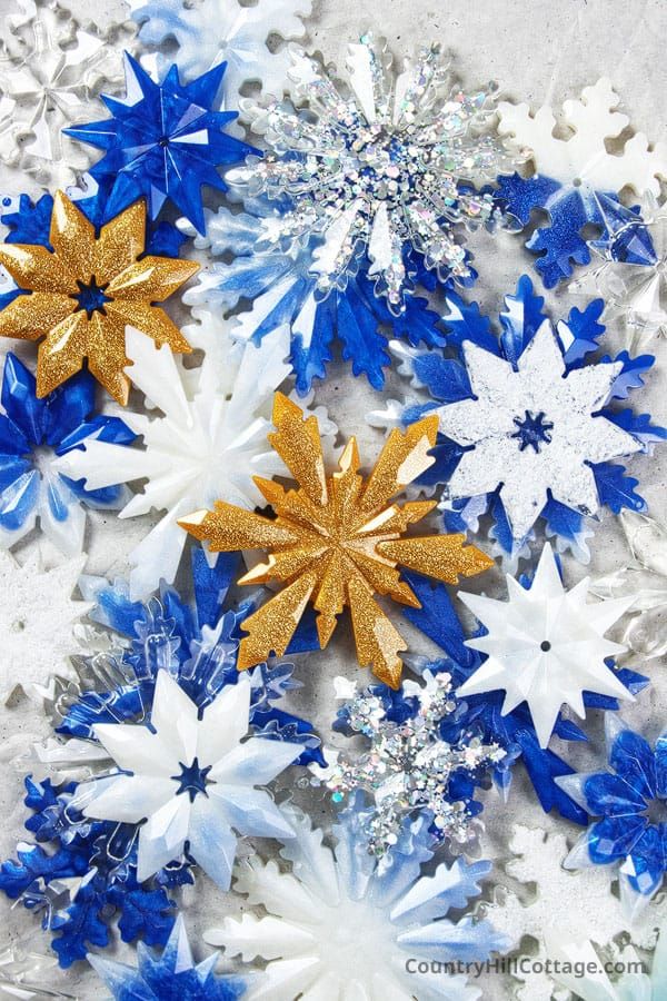 blue and white paper snowflakes with gold glitter stars on the top, in an arrangement