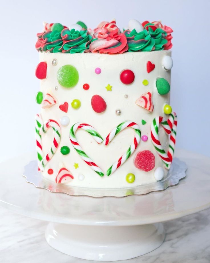 a white cake decorated with candy canes and candies on top of a plate