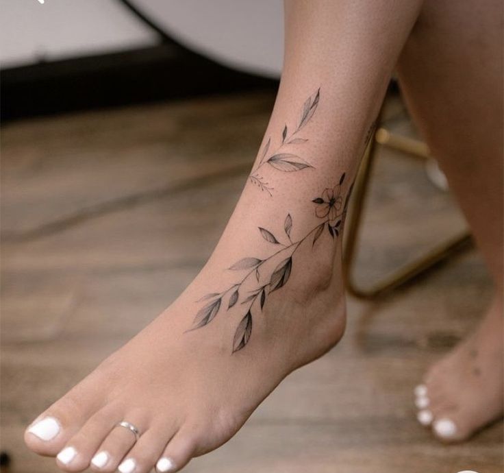 a woman's foot with a flower tattoo on her left side and the bottom part of her leg