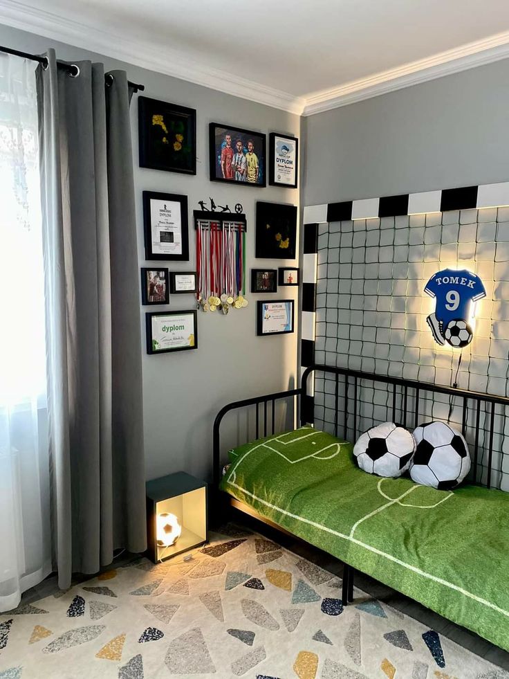 a bedroom with a soccer themed bed and pictures on the wall