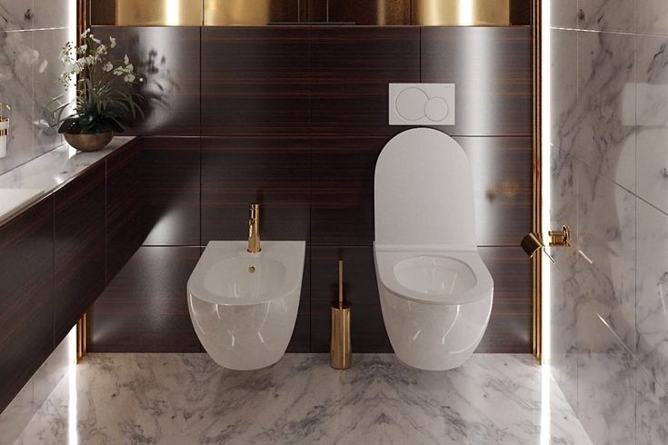 two white toilets sitting next to each other in a bathroom with marble walls and floor