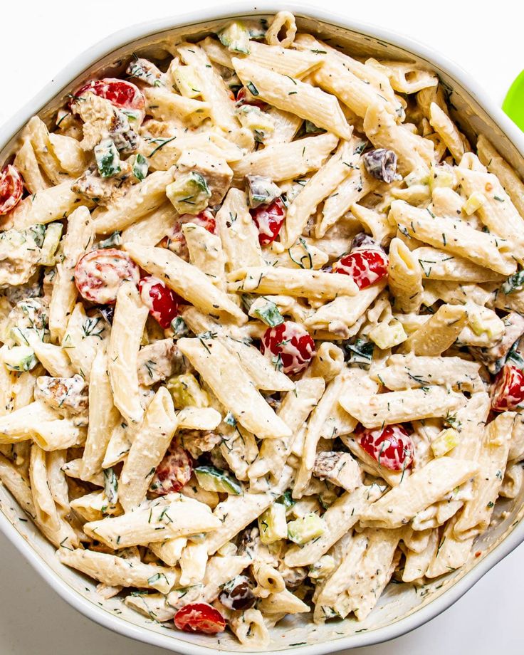 a white bowl filled with pasta salad on top of a table