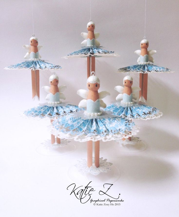 an ornament made to look like ballet dancers on sticks with ribbons hanging from them