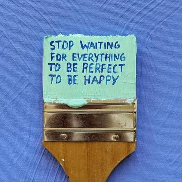 a blue wall with a sign on it that says stop waiting for everything to be perfect to be happy